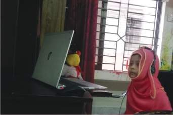 হেডফোন পরে এক শিশু ল্যাপটপের সামনে বসে আছে